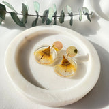 Small round resin dangle with yellow gum blossom and gold top