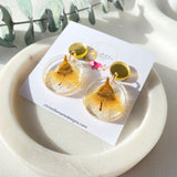 Small round resin dangle with yellow gum blossom and gold top