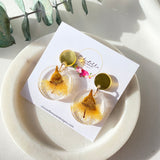 Small round resin dangle with yellow gum blossom and gold top